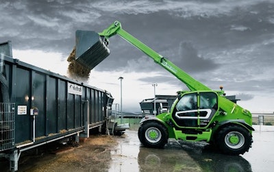 Merlo TF65.9 telehandler green dumping material in truck trailer