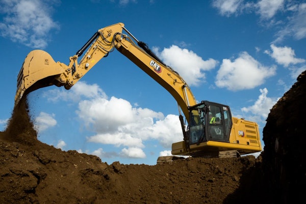 Cat 320 Electric Excavator dumping a bucket of dirt