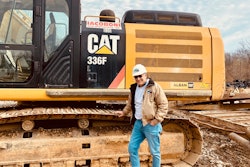Tom Iacoboni owner Iacoboni Site Specialists leaning on track of Cat 336F excavator in hardhat jeans