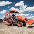 Kubota L47 Tractor Loader Backhoe carrying a load of aggregate