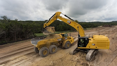 Caterpillar 352 excavator dumping load into truck