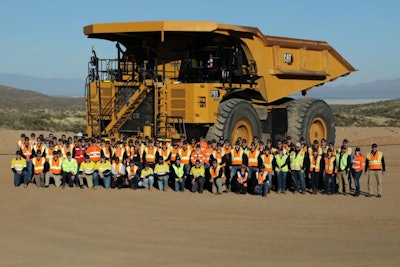Cat 793 electric mining dump truck with crowd of people posed in front
