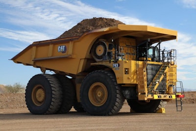Cat 793 electric mining dump truck with full load of dirt parked desert