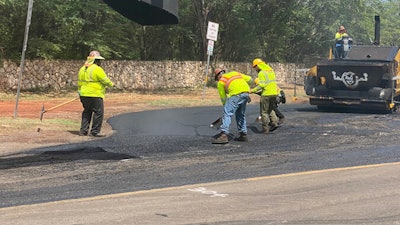 Hawaii paving crew smoothing asphalt on road