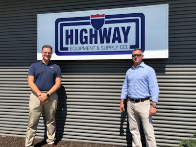 Highway Equipment & Supply Co. owners in front of company sign