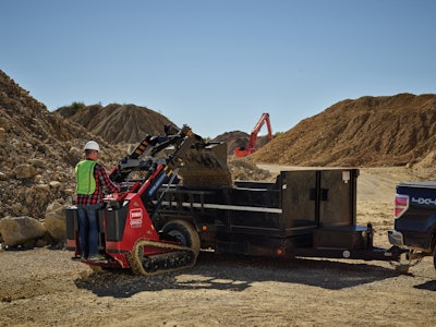 Toro Dingo TX1300 compact utility loader dumping dirt in trailer bed in qaurry