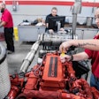 Female diesel tech at UTI working on Cummins engine