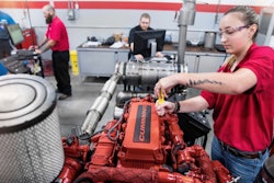Female diesel tech at UTI working on Cummins engine