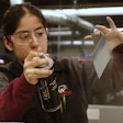 Female diesel tech student Wyoming Tech sprays hand-held part