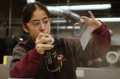 Female diesel tech student Wyoming Tech sprays hand-held part