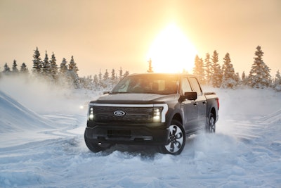 Ford F-150 Lightning Alaska in snow with trees and the sun in the background