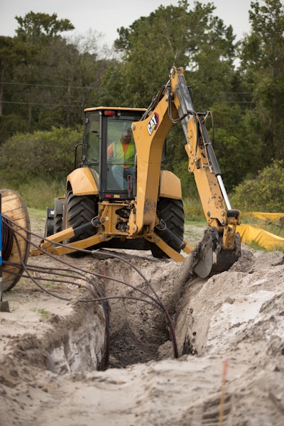 Cat 420 XE backhoe digging trench