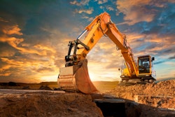 stock image of yellow excavator digging in dirt