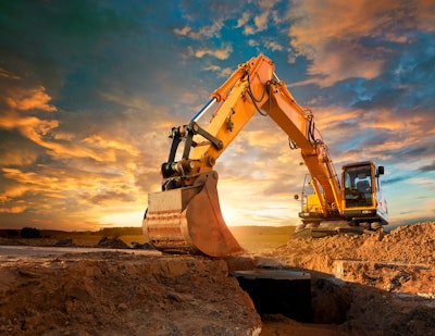 stock image of yellow excavator digging in dirt