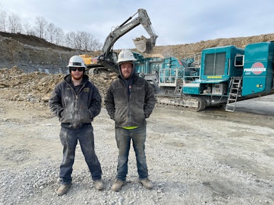 Employees at Pro Lawn Care & Landscaping next to a crusher