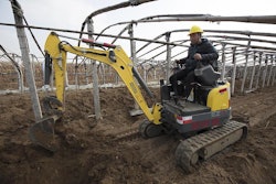 Wacker Neuson EZ17 compact excavator digging beside and under frame structure