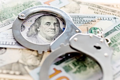 stock image handcuffs in top of $100 bills