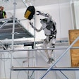 Boston Dynamics humanoid robot Atlas tosses a tool bag to a worker on a scaffold