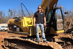 Todd Bennick standing on tracks of Caterpillar excavator