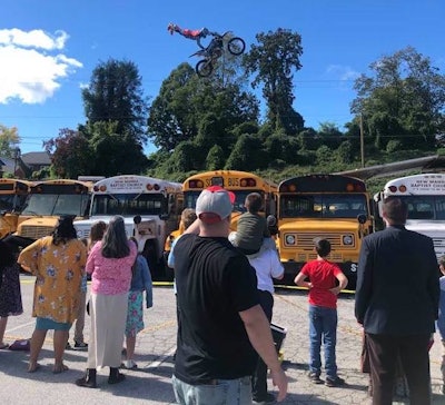 Todd Bennick flies over buses on motorcycle with legs extended behind him