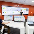 Doosan Smart X-Care telematics monitoring center with large computer screens for tracking construction equipment