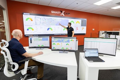 Doosan Smart X-Care telematics monitoring center with large computer screens for tracking construction equipment