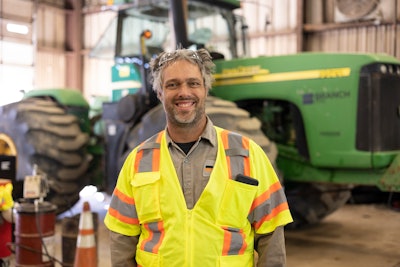 Technician of the year Robert Kesselring in shop with John Deere tractor in background
