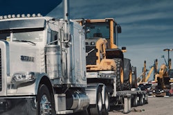 Semi hauling a piece of heavy equipment from an auction yard