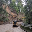 Construction equipment clearing trees and mud from State Route 9 in Santa Cruz California