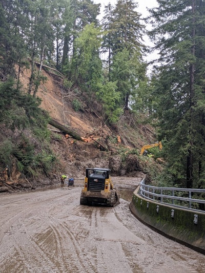 Construction equipment clearing trees and mud from State Route 9 in Santa Cruz California