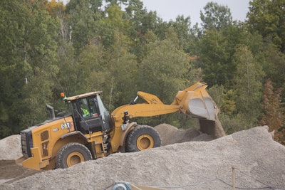 Caterpillar 962 next generation medium wheel loader dumping dirt