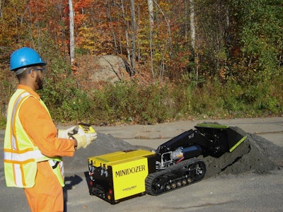 worker controling Movex Track-O M-47 Minidozer moving ash pile