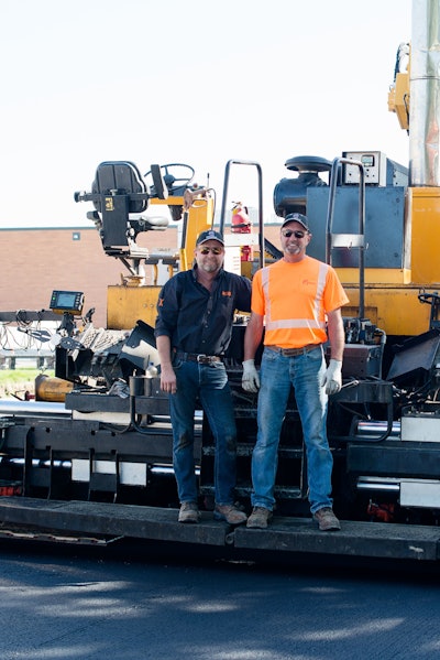 brothers Stuart and Michael Frost pose on back of paver