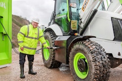 Lord Bamford refuels a hydrogen-powered backhoe prototype
