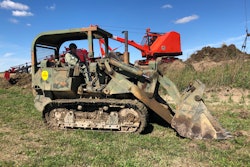 1972 Case Marine Corps 1150 track loader on grassy field in front of red antique crawler crane