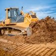 yellow dozer pushing pile of dirt