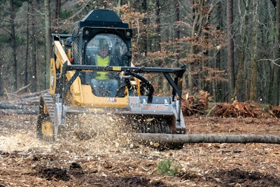 FAE BL4/SSL forestry mulcher attachment on Caterpillar compact track loader mulching felled tree in woods