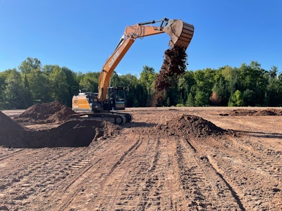 Case E Series Excavator dumping a bucket of dirt