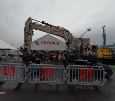 A military-themed wrapped excavator from Bottom Line Equipment in the Oil Quick booth.