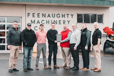 Brendan Green accepts the 2022 Takeuchi Dealer of the Year award from Jeff Stewart