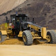 Cat 24 Motor Grader cleaning a haul road at a mine