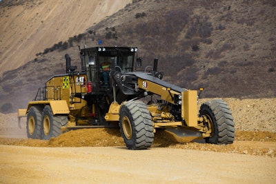 Cat 24 Motor Grader cleaning a haul road at a mine