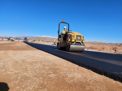Cat CC2.7 GC tandem-drum compactor on newly paved asphalt road in desert