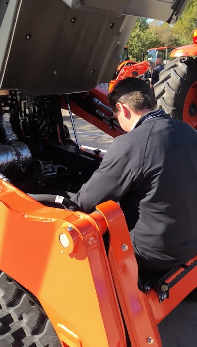 Kubota SVL75-3 with service compartment beneath cab opened man inside