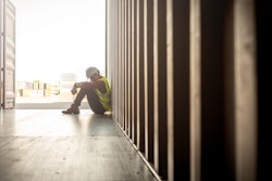 Construction worker sitting on the floor in despair