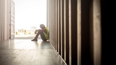 Construction worker sitting on the floor in despair