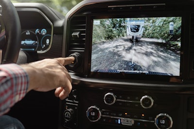 man's finger touching dial on dashboard camera showing Ford's new Pro Trailer Hitch Assist
