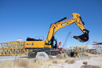 Sany SY750H large excavator on building construction site with bucket raised midway