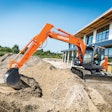 Hitachi ZX135US-7H ultrashort tail swing excavator working near a commercial building