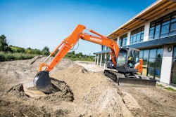 Hitachi ZX135US-7H ultrashort tail swing excavator working near a commercial building